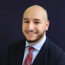 smiling man wearing a blue suit and tie