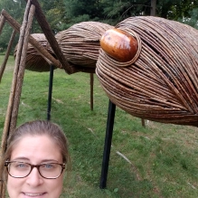 Woman with glasses standing in front of a large ant statue