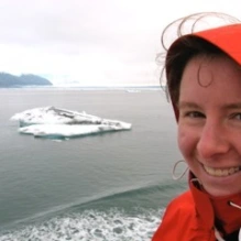 smiling woman next to icy waters